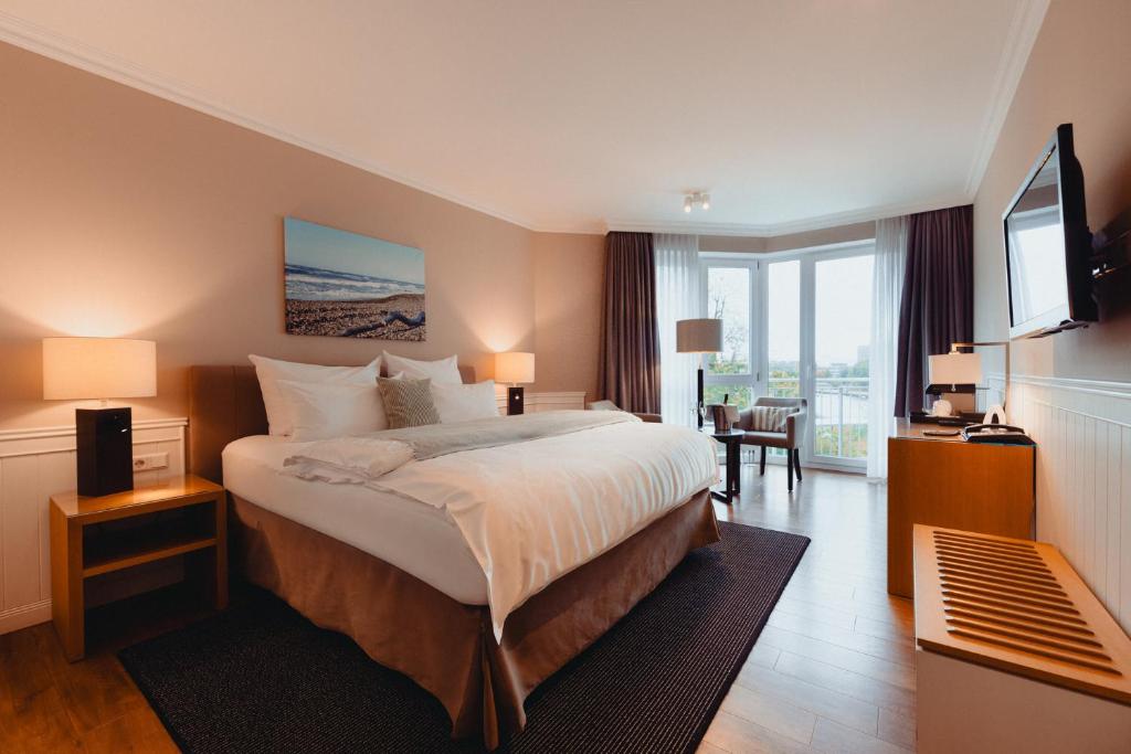 a hotel room with a bed and a large window at Conventgarten Hotel & Restaurant - direkt am Nord-Ostsee-Kanal in Rendsburg