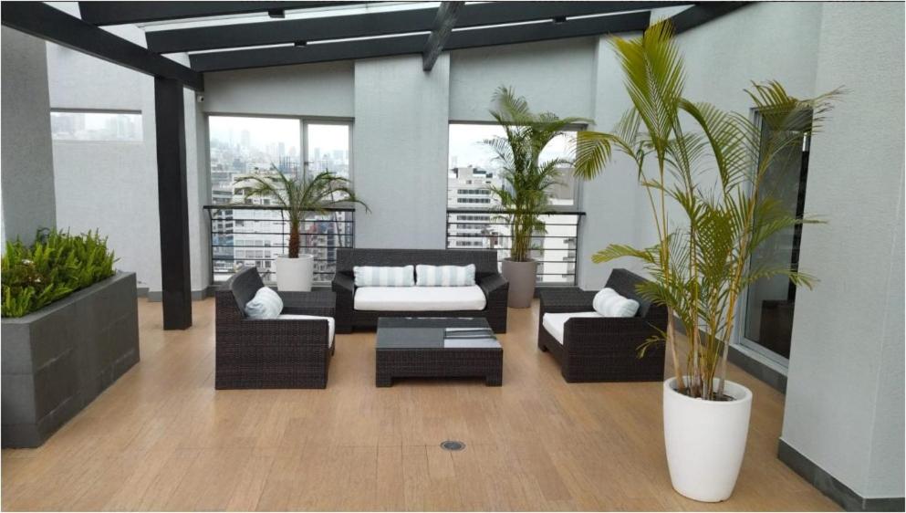 a living room with couches and potted plants at Hospedaje en Quito Sectro Financiero in Quito