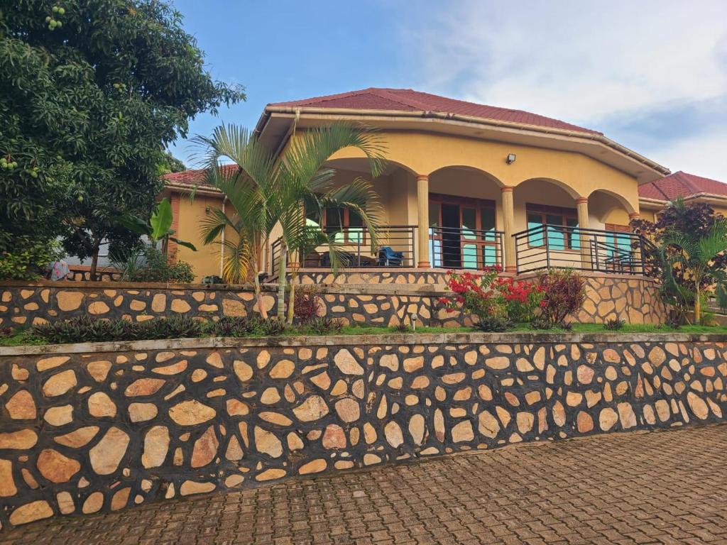 a yellow house with a fence in front of it at Good Times in Kampala
