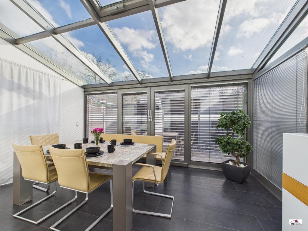 a dining room with a table and chairs and windows at Winter Garden Dream Steinheim in Steinheim an der Murr