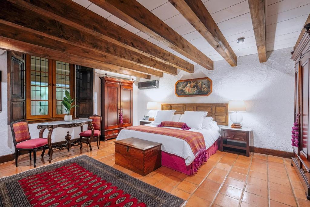 a bedroom with a bed and a table and chairs at Las Cruces Boutique Hotel in Antigua Guatemala