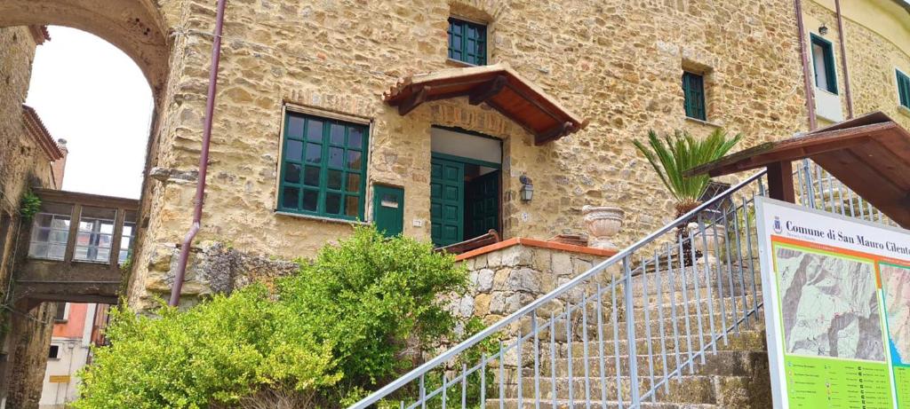 サン・マウロ・チレントにあるSteinhaus Cilentoの緑のドアと階段が正面にある建物