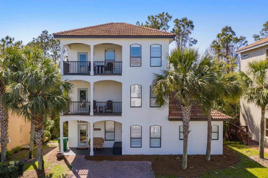 una casa bianca con palme di fronte di Sandy Bottoms a Santa Rosa Beach