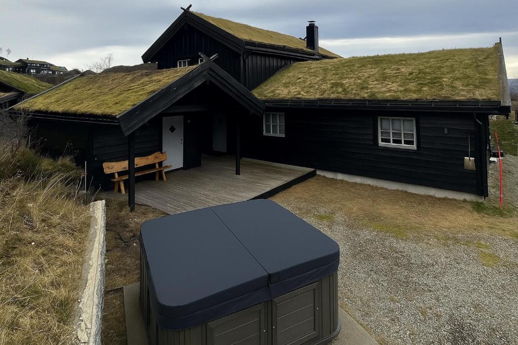 een groot zwart huis met een grasdak bij Nice cottage in quiet surroundings, surrounded by beautiful nature, near Gullingen in Gullingen