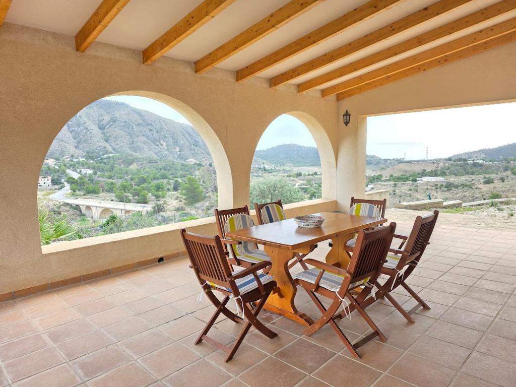 a dining room with a table and chairs and windows at mirador del collao in Orcheta
