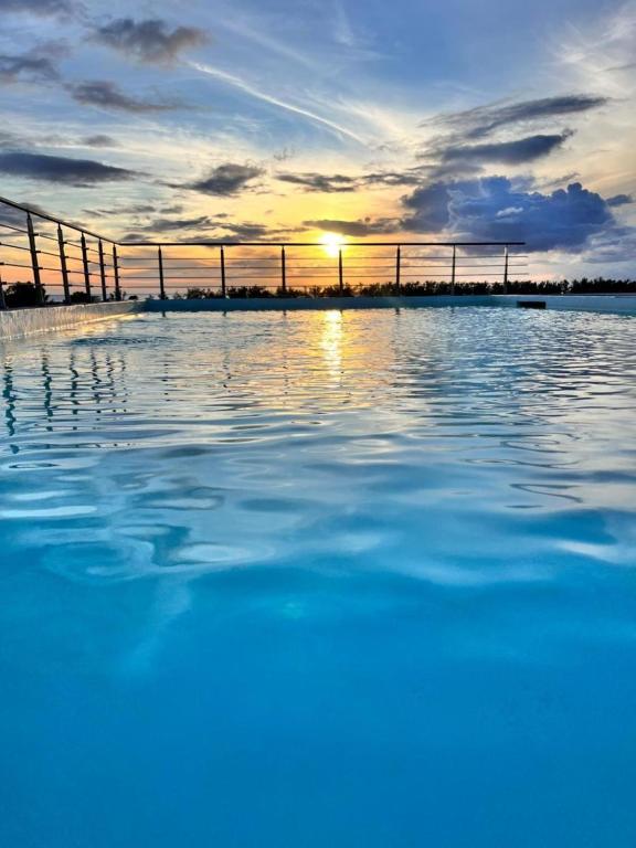 a body of water with the sunset in the background at Coastal Calm The Cove 2 in Flic-en-Flac