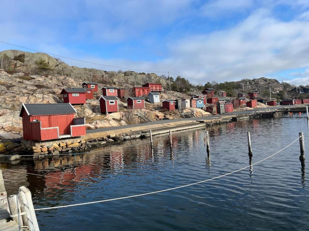 a group of houses on the side of a body of water at Close to Gothenburg & the sea - with your own sauna! in Billdal