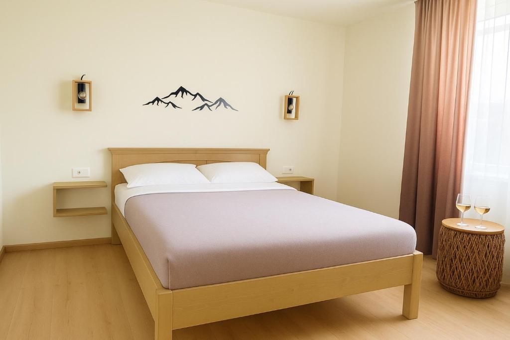 a bedroom with a large bed with mountains on the wall at Transrarau Lodge in Pojorîta