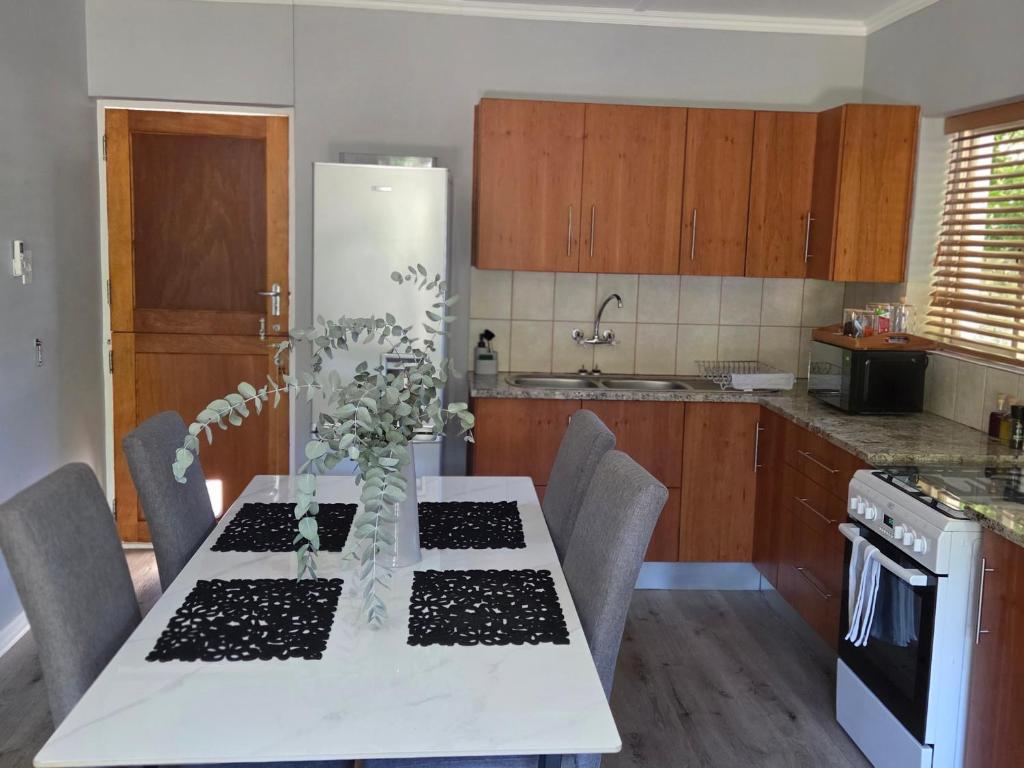 a kitchen with a table with chairs and a white table sidx sidx sidx at Roux Casa in Swellendam