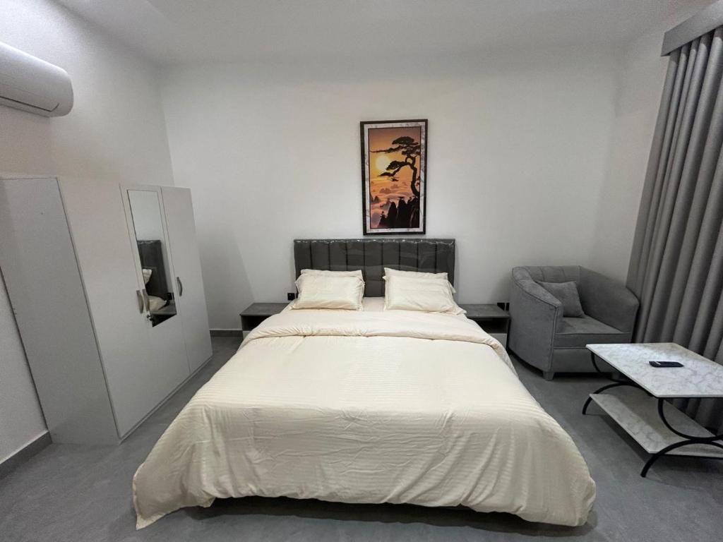 a bedroom with a large bed and a chair at قمرة قباء Cuba moon2 in Al Madinah