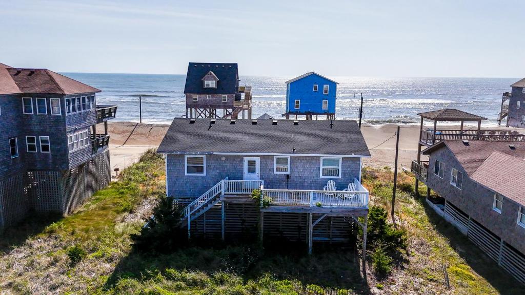 a blue house on the beach next to the ocean at 8077 - Beachin' It in South Rodanthe