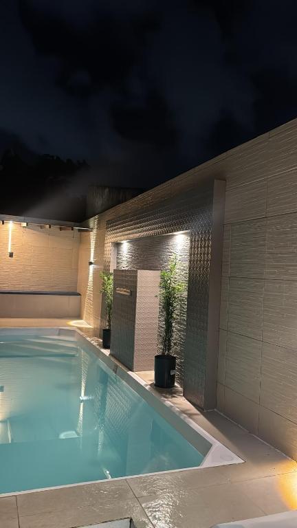 a swimming pool with lights on the side of a building at Casa aconchegante com piscina e wi-fi rápido in Aracaju