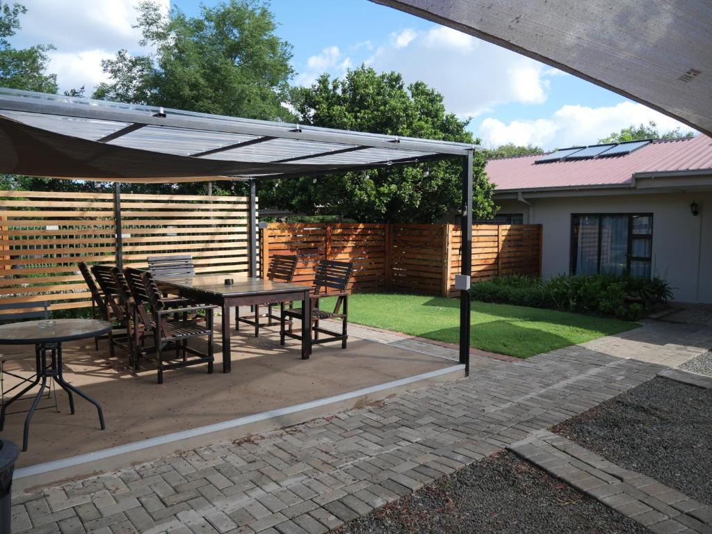 a patio with a table and chairs under an umbrella at Turn and slip in Bloemfontein