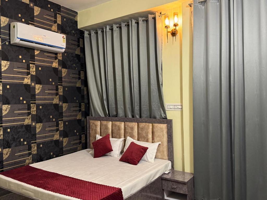 a bedroom with a bed with red pillows at SUNRISE INN hotel in Bikaner