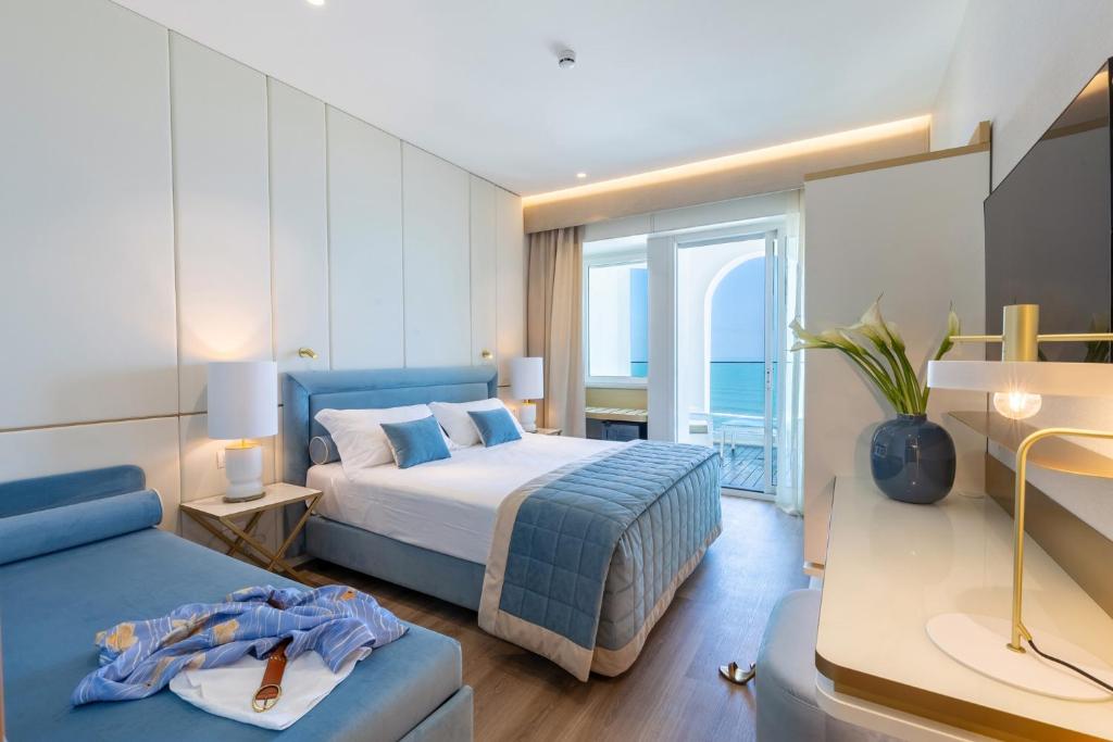 a bedroom with a bed and a blue couch at Hotel Tiffany's in Riccione