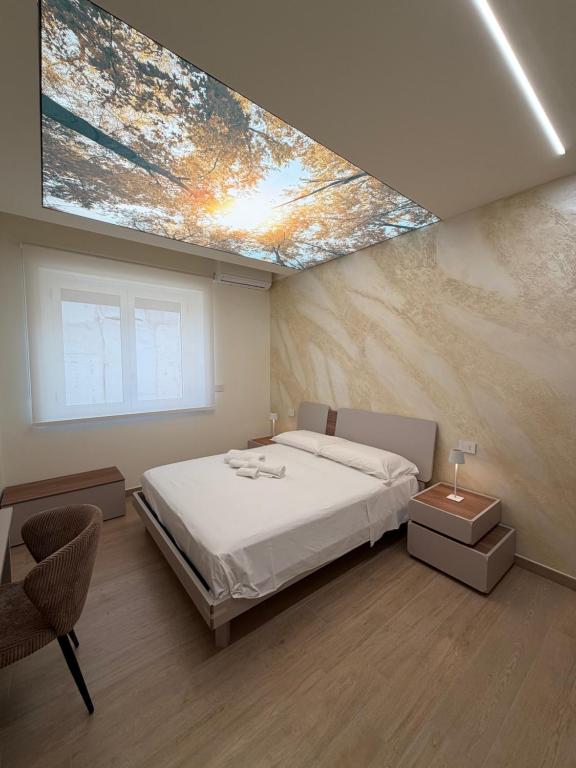 a bedroom with a large bed and a skylight at Ludogà Luxury Suite in Trebisacce