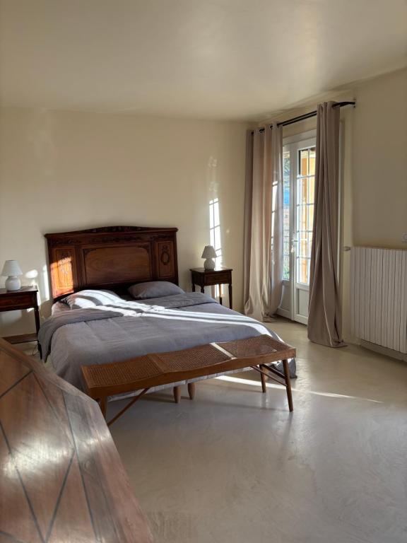 Un dormitorio con una cama y una ventana grande. en Le Mas des Vignes en Drome provençale, en Rochegude