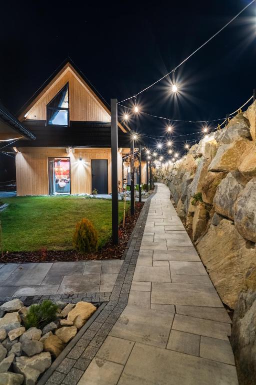 a stone pathway in front of a house at night at TATRZAŃSKIE TARASY Luxury Chalets in Małe Ciche