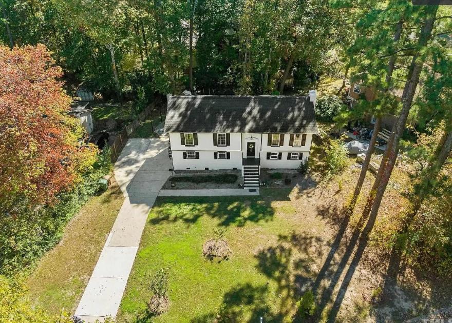 vue aérienne d'une maison blanche dans une cour dans l'établissement Stylish 4BR Getaway with Game Room, Grills & Cozy Outdoor Fire-Pit, à Cary