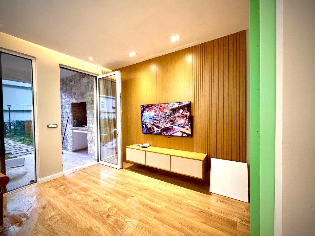 a living room with a television on a wall at Next to Melia-Premium Zone, Private Garden Apartment - SanPietro Resort in Draçi