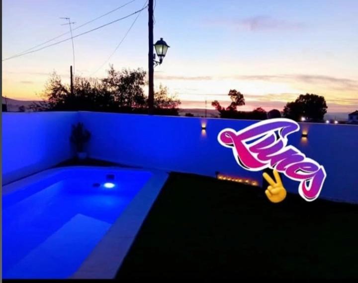 a blue wall with a swimming pool with a sign on it at O Caminho Azul in Olivenza