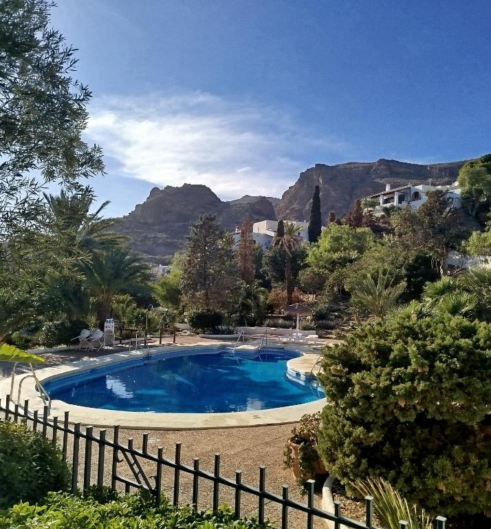 a blue swimming pool with mountains in the background at Apartament Maria F in Mojácar