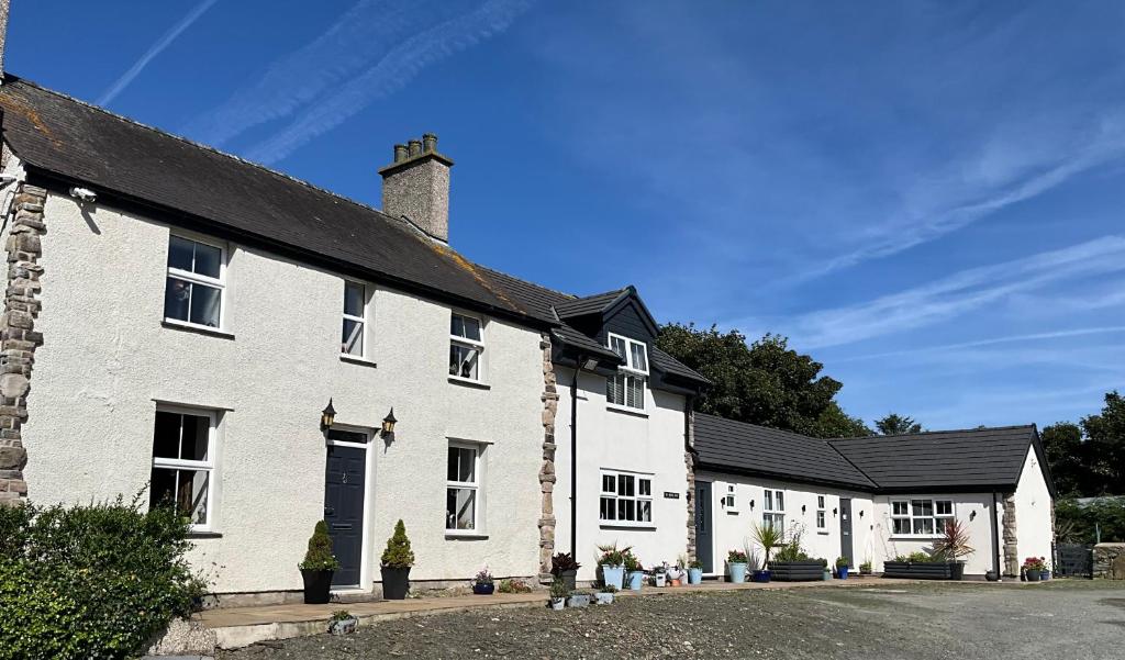 a white building with a black roof at Superb Location - 'The Annexe' - at Ty Moel Isaf in Amlwch