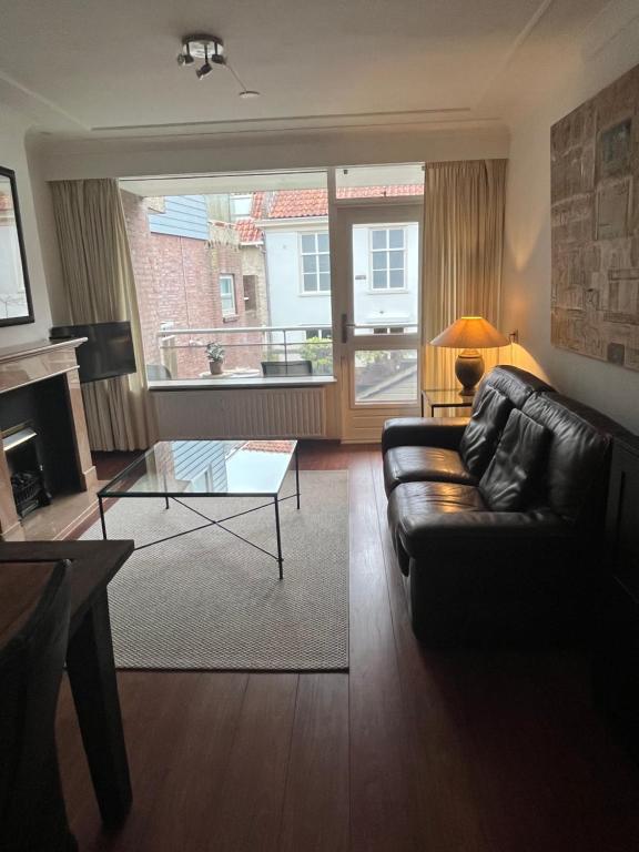 a living room with a leather couch and a glass table at Franciscus in Bergen op Zoom