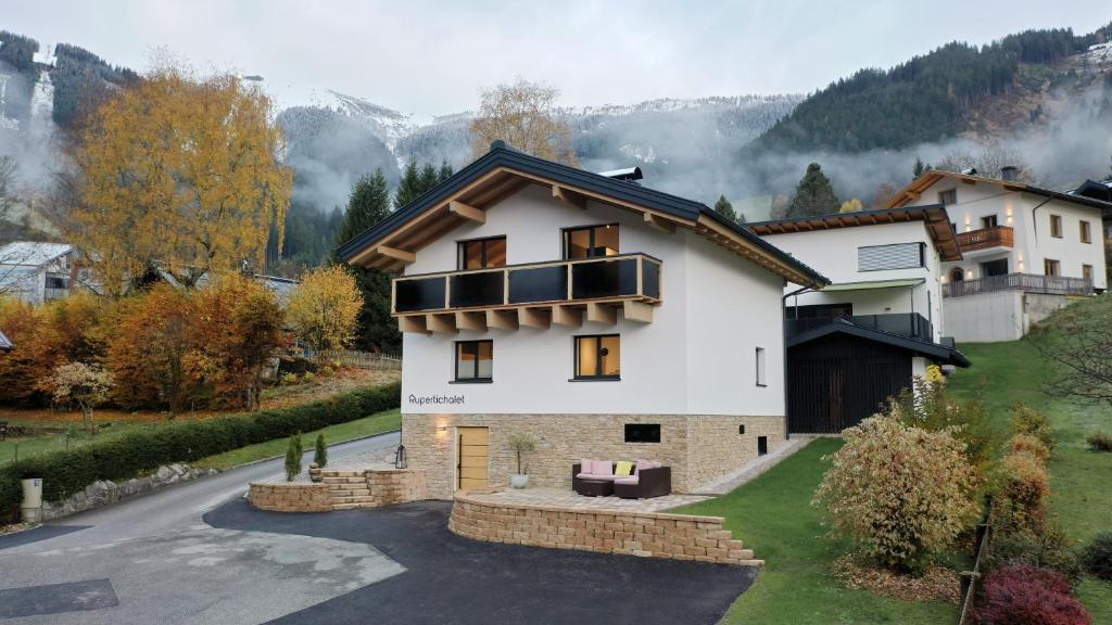 a large white house with a balcony on a road at Rupertichalet in Zell am See