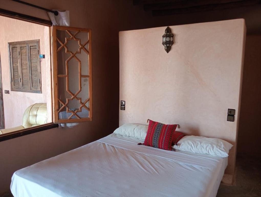 a bed with two pillows on it in a bedroom at LA HACIENDA Agafay Desert 