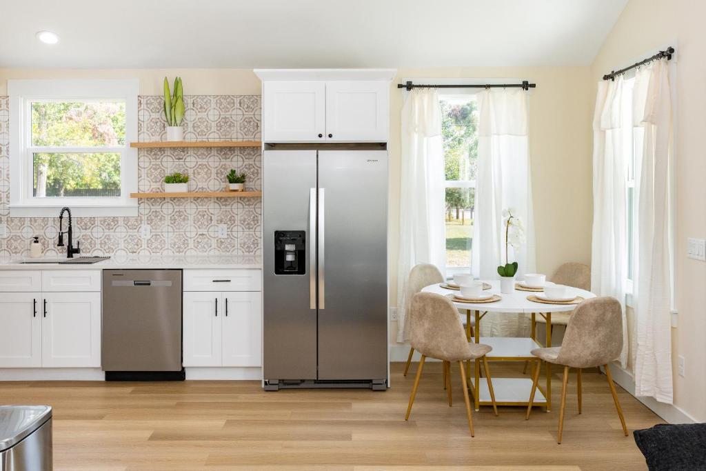a kitchen with a refrigerator and a table with chairs at Free parking, Free WiFi 2 bed home in Tampa