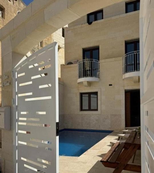 an external view of a building with a swimming pool at Dar il-Wied in Għajn il-Kbira
