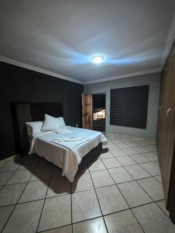 a bedroom with a bed and a tile floor at The Good Samaritan 3 in Witbank