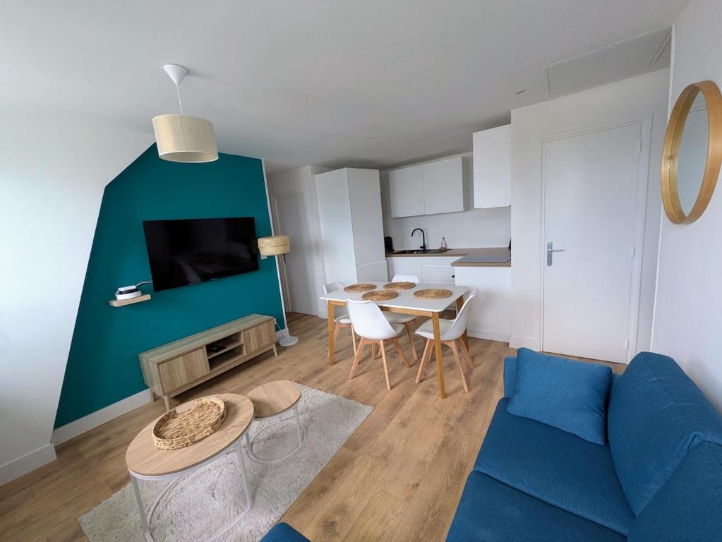 un soggiorno con un divano blu e un tavolo di Cozy and bright 3 bedrooms teleworking Vannes a Vannes