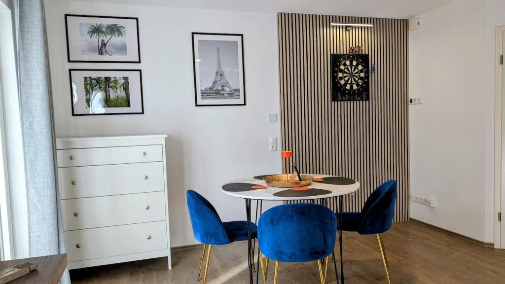 een eetkamer met een tafel en blauwe stoelen bij FEWO VRONI - Wohlfühlambiente mit Stil und Terasse in Rattelsdorf