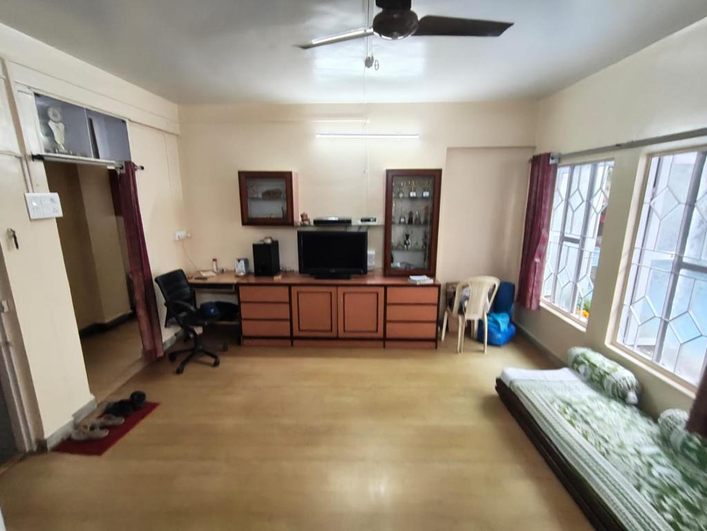 a living room with a desk and a tv in it at Veenus Residency - Chinchwad in Chinchwad