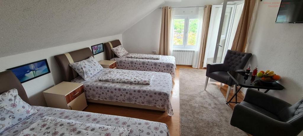 a hotel room with two beds and a chair at VISOKO Room in Visoko