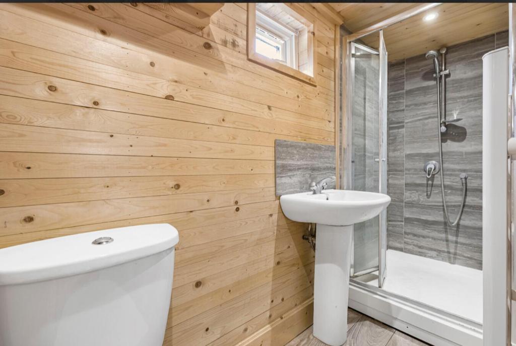 Un baño con un inodoro blanco y un lavabo. en Windy Wood, en Hatfield