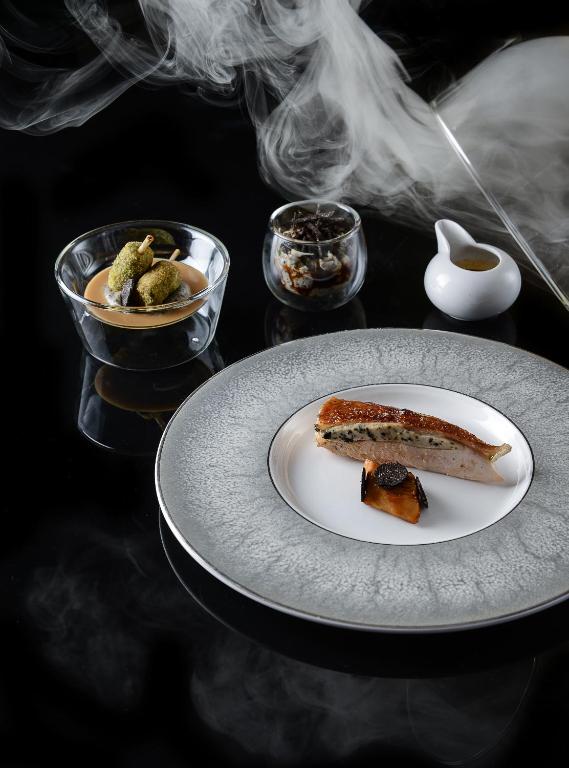 a plate of food on a table with smoke at Le Kaïla in Méribel