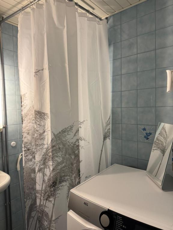 a bathroom with a shower curtain and a printer at City center apartment in Rovaniemi