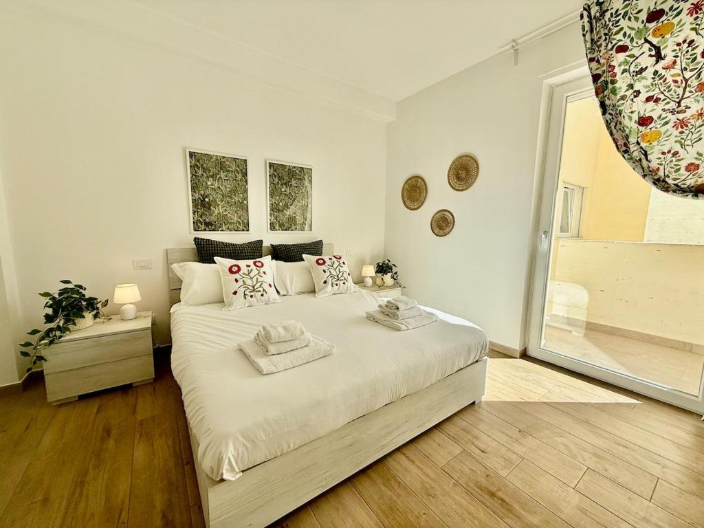 Un dormitorio blanco con una cama grande y una ventana. en Suite dei Principi 3, aeroporto e parcheggio gratuito, en Bari