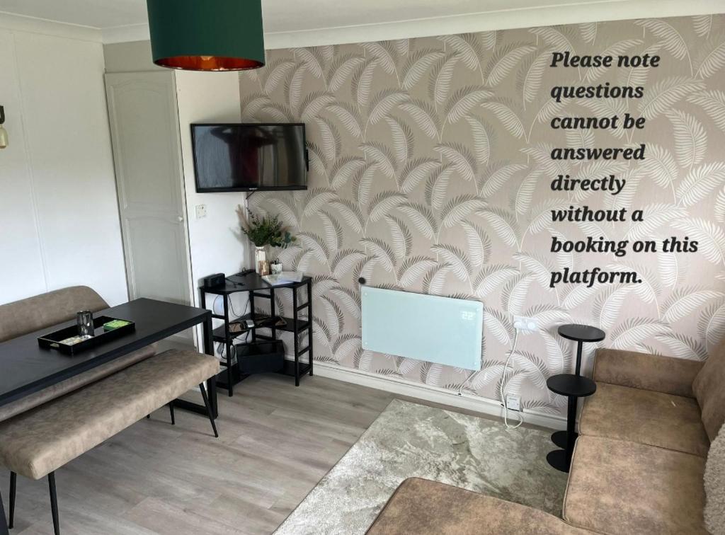 ein Wohnzimmer mit einem Sofa und einem Fernseher an der Wand in der Unterkunft Home on the Broads Just Renovated in Lowestoft