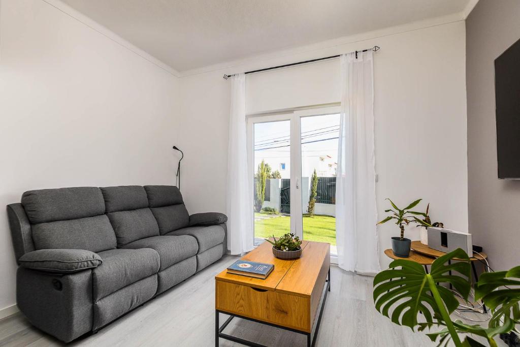 a living room with a couch and a table at Private Room in Family Home with Pool in Sesimbra