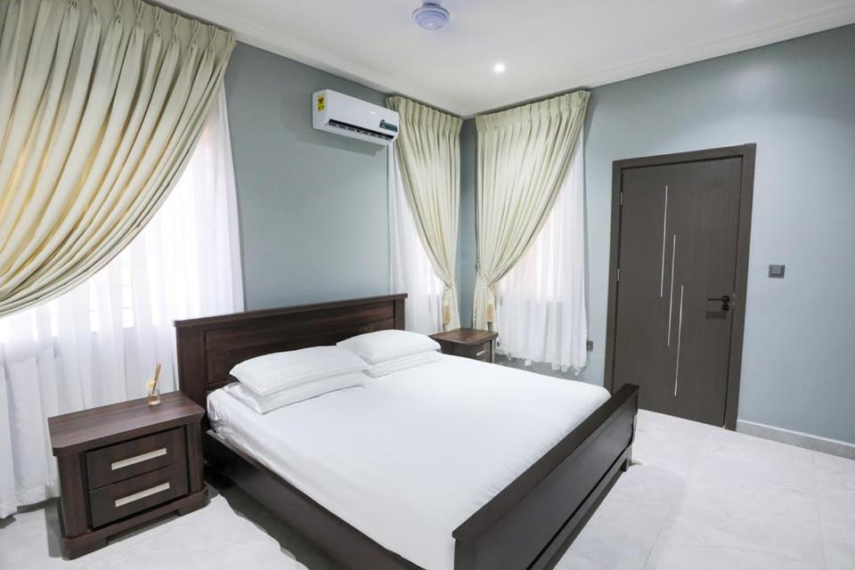 Un dormitorio con una cama blanca y una ventana. en BMS Lodge, en Kumasi