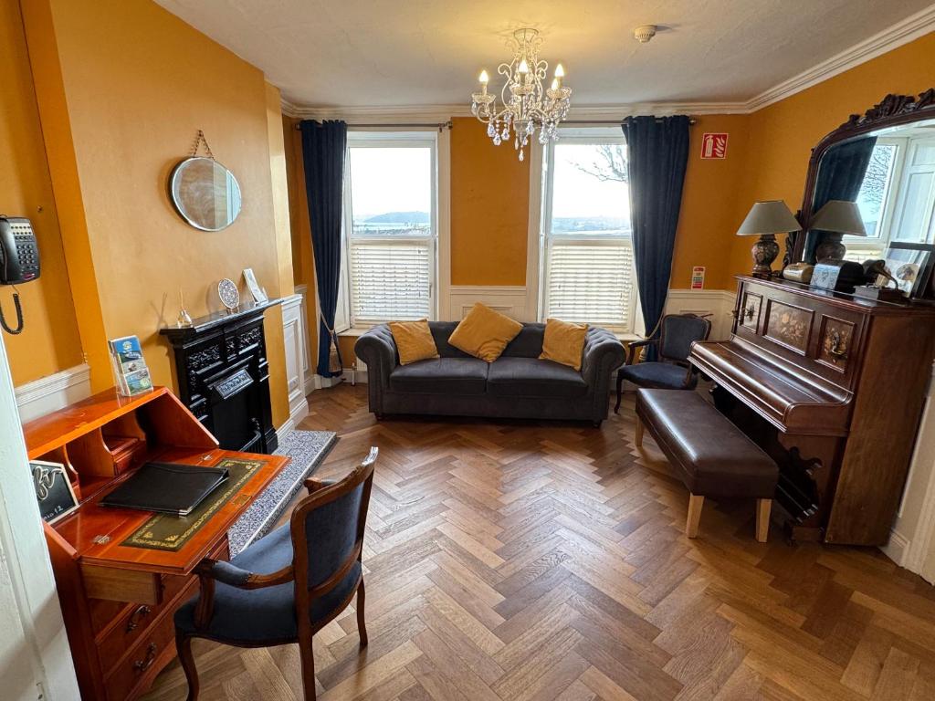 a living room with a couch and a piano at The Sardinian Guesthouse (6 Bedrooms) in Cobh