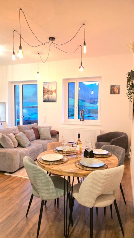 a living room with a table and chairs and a couch at Black Forest -5- I Design-Apartment I 2 Etagen I Terrasse & Balkon mit Ausblick I Boxspring I Nespresso in Oberharmersbach