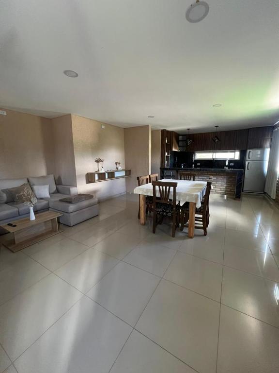 ein großes Wohnzimmer mit Tisch und Couch in der Unterkunft El descanso in Villa del Dique