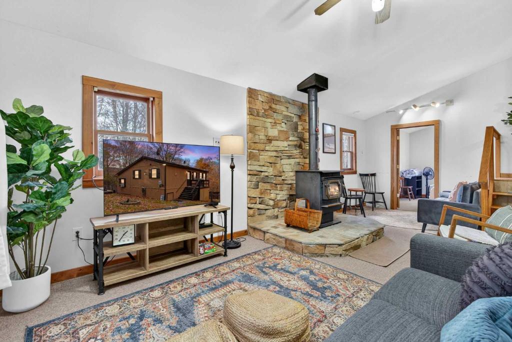 a living room with a tv and a fireplace at River Access Cabin with Hot Tub, Fire Pit, & WiFi! in Morton Grove