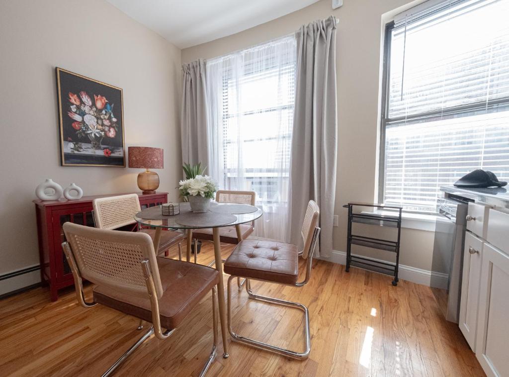 a kitchen and dining room with a table and chairs at Sunlit 2BR Central Park North elevator & laundry in New York