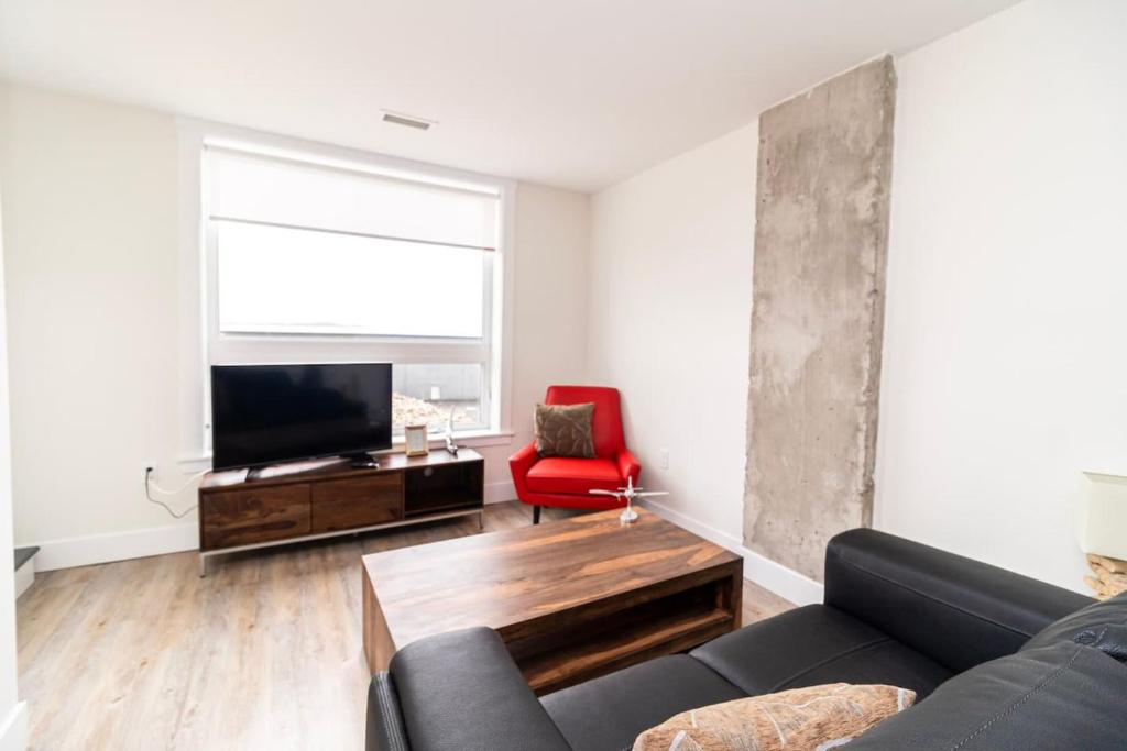 een woonkamer met een bank, een tv en een rode stoel bij Corporate Stays Junction 1 Bedroom in Halifax